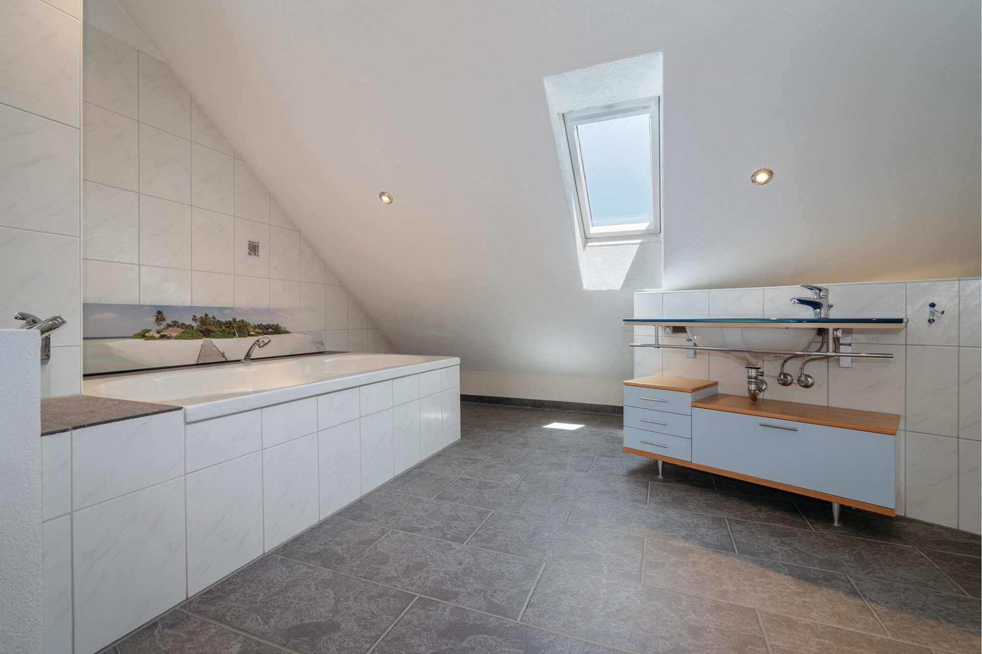 Dachgeschoss-Badezimmer mit Badewanne und Dachfenster