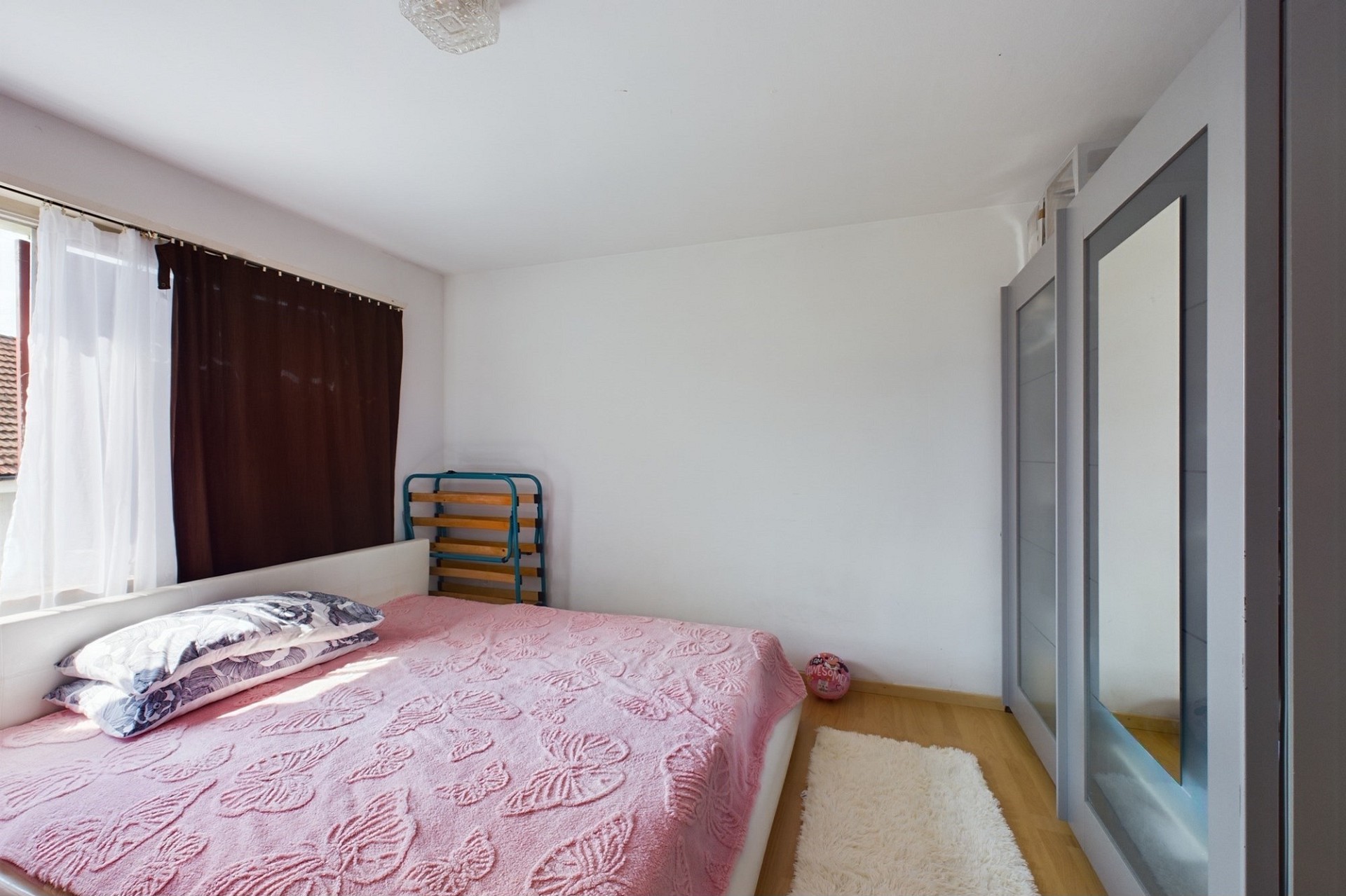 Helles Schlafzimmer mit Bett und Kleiderschrank