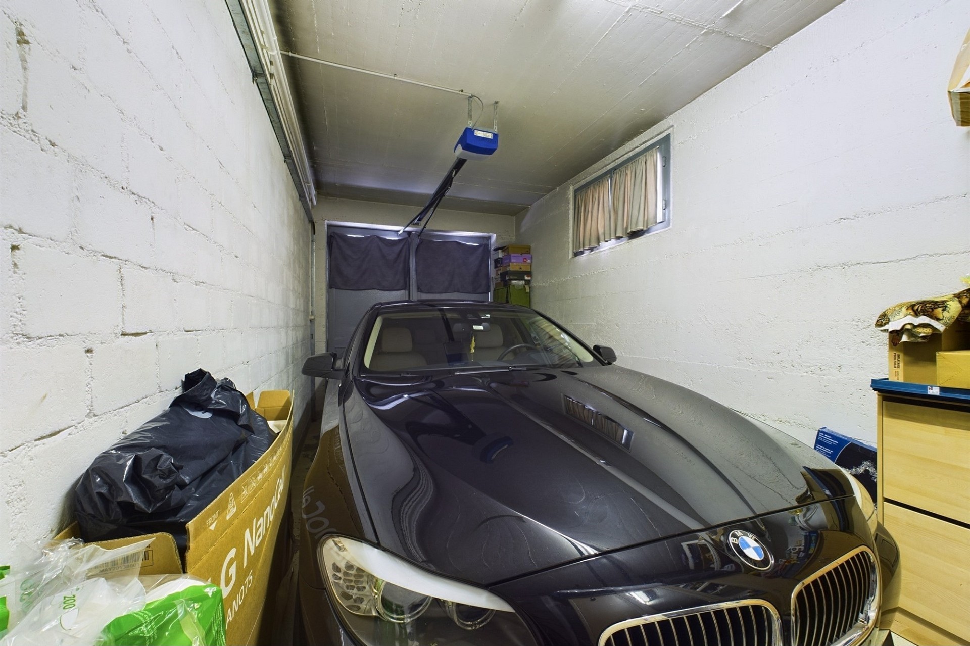 Garage mit geparktem Auto und Lagergegenständen