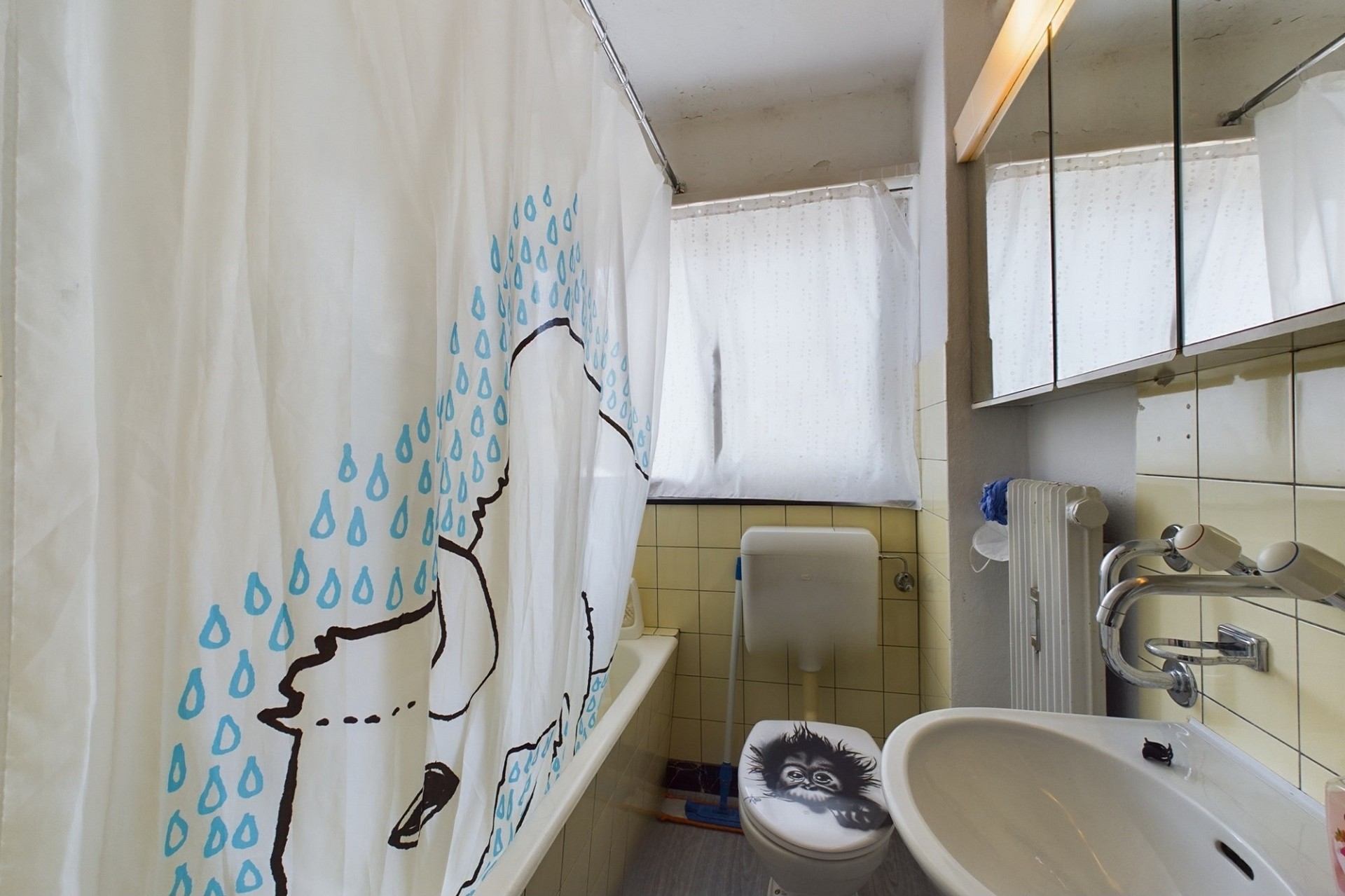 Kleines Badezimmer mit Badewanne, WC und Spiegeln