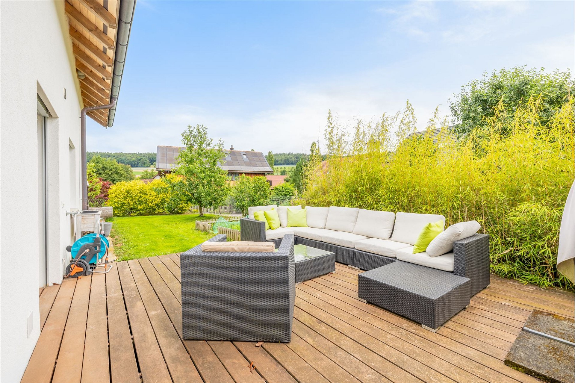 Terrasse mit Gartenlounge und Blick ins Grüne