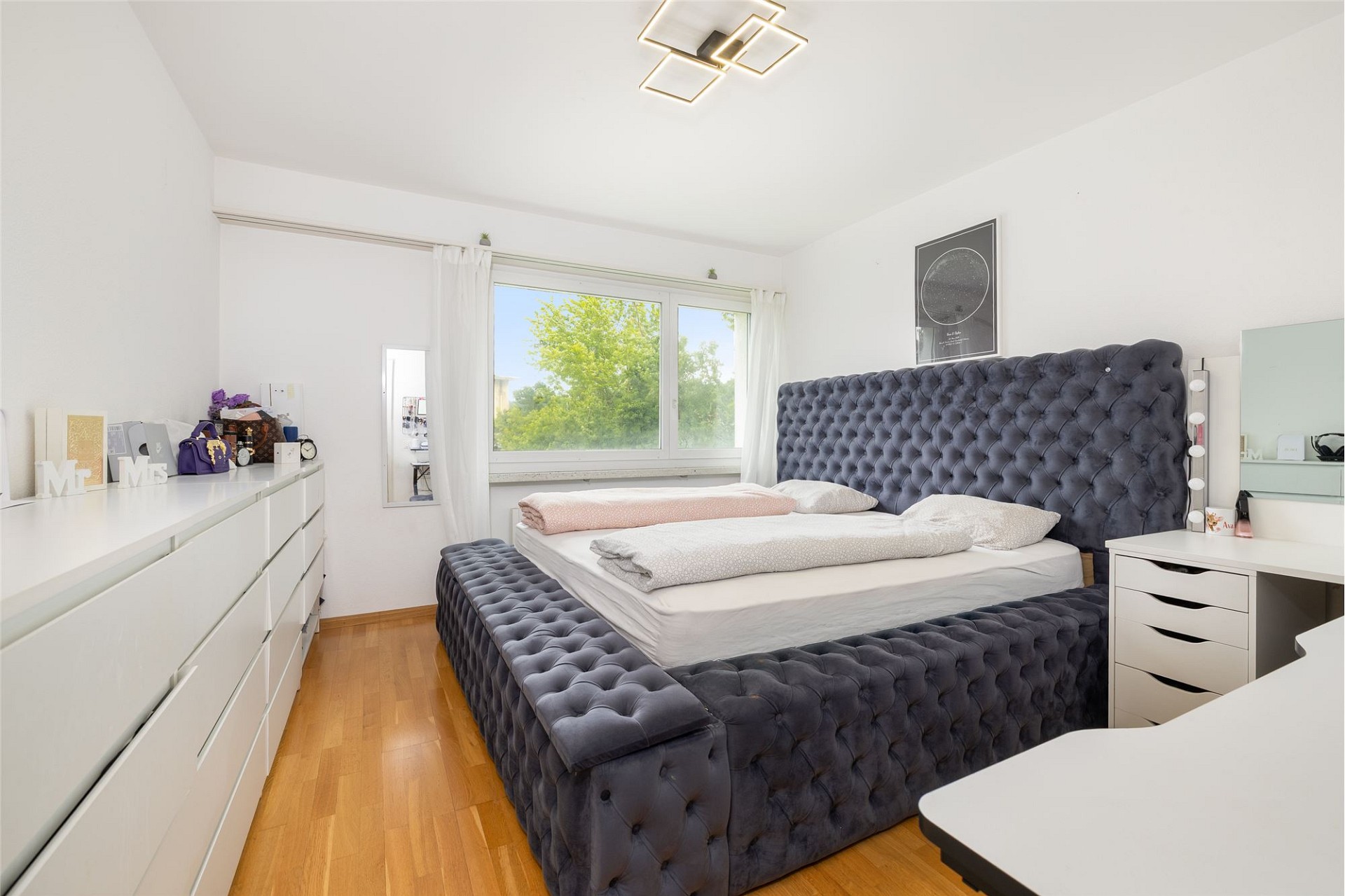 Helles Schlafzimmer mit dunklem Polsterbett