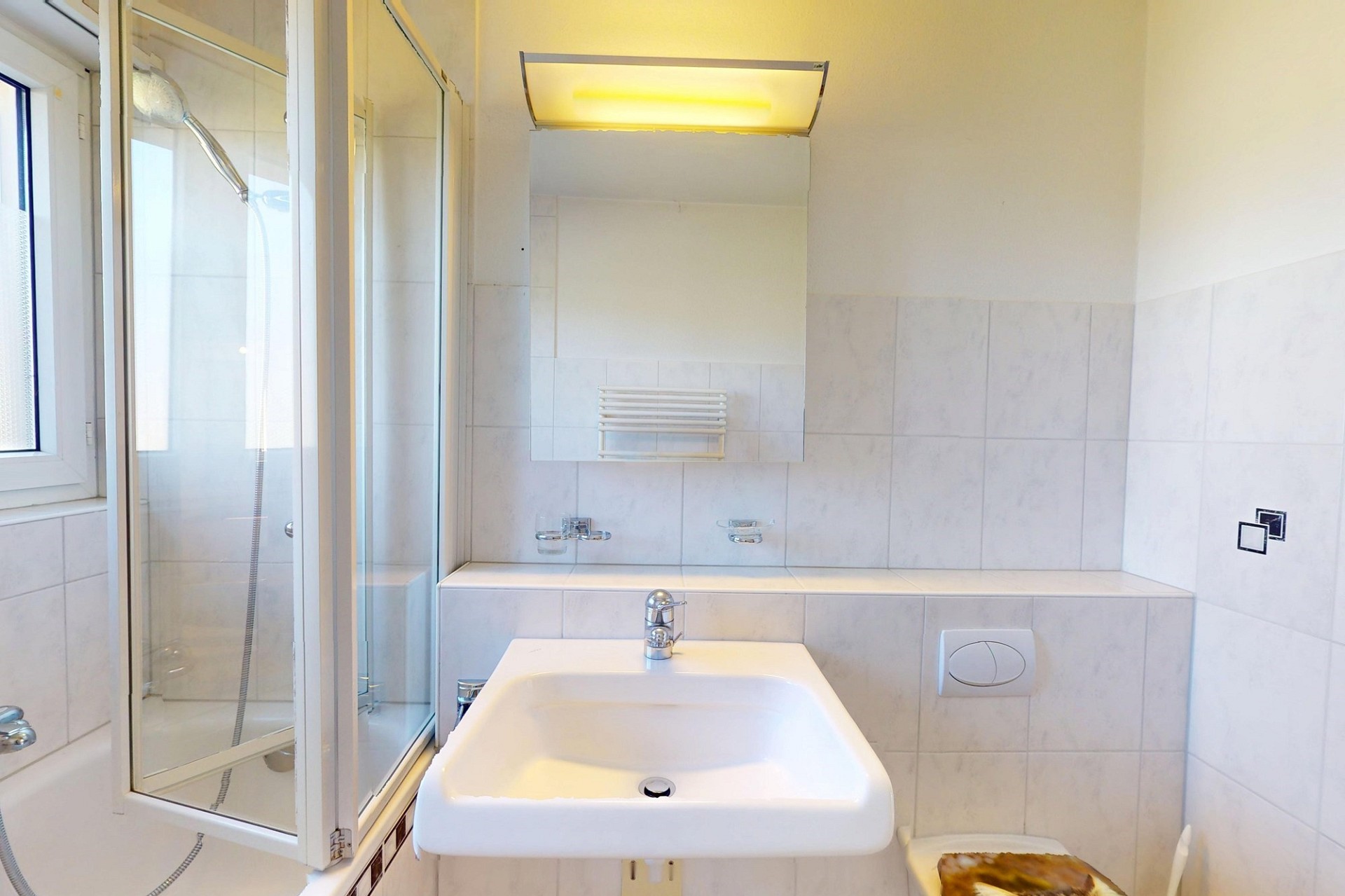 Helles Badezimmer mit Dusche und Waschbecken
