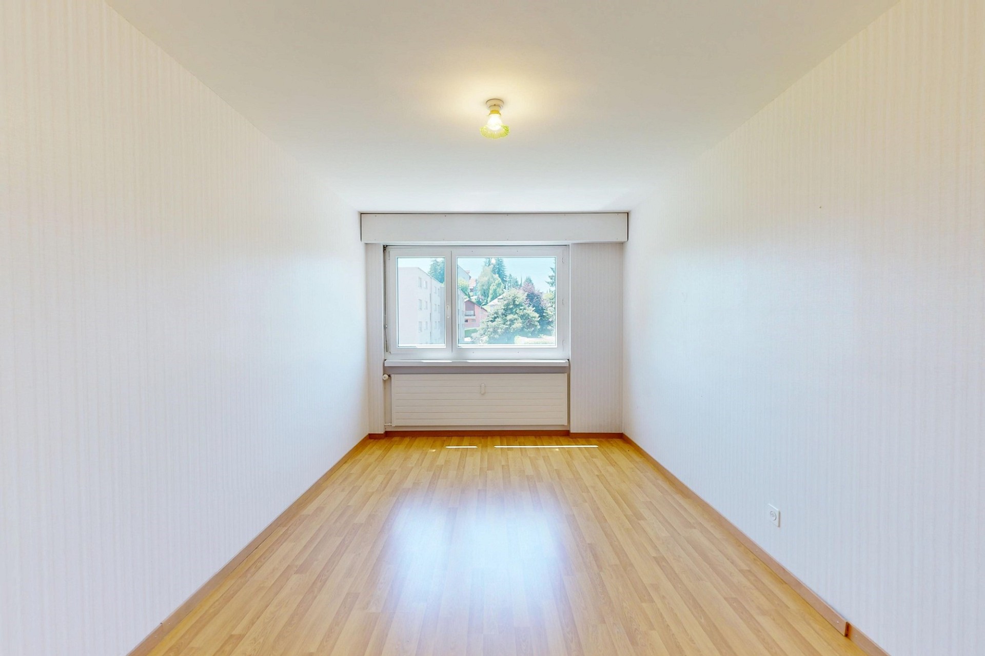 Heller, leerer Wohnraum mit Fenster