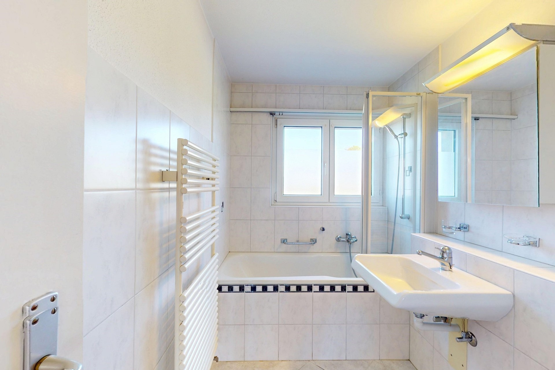 Helles Badezimmer mit Badewanne und Doppelwaschplatz