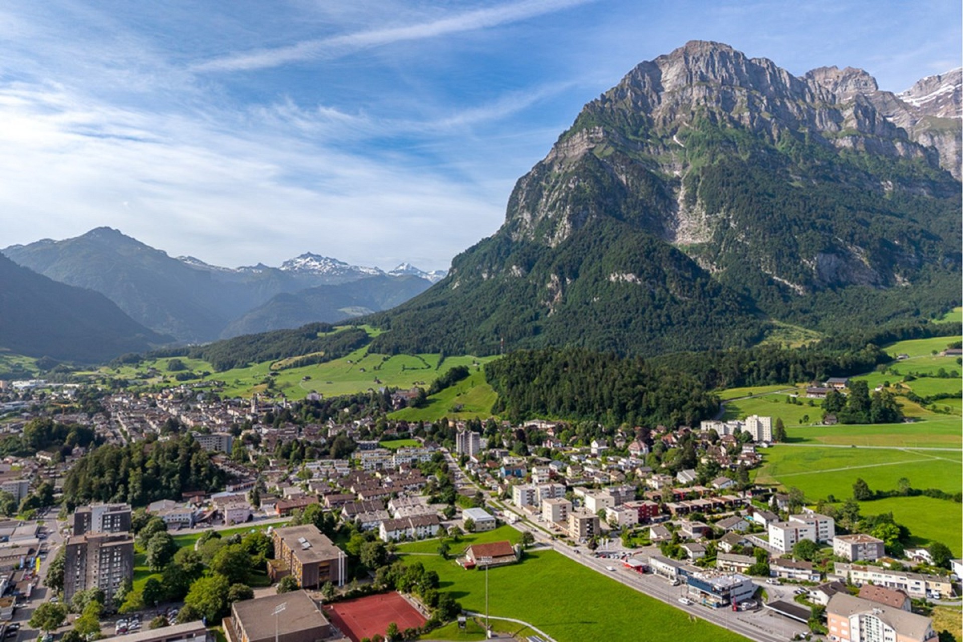 Luftaufnahme einer alpinen Stadt mit Bergpanorama