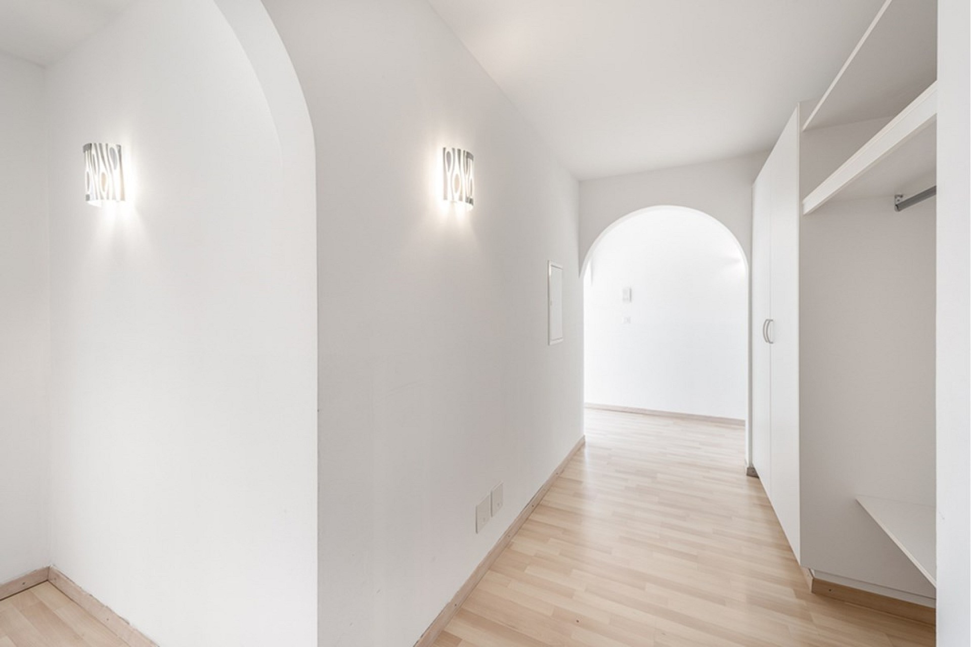Heller Flur mit Rundbögen und Einbauschrank