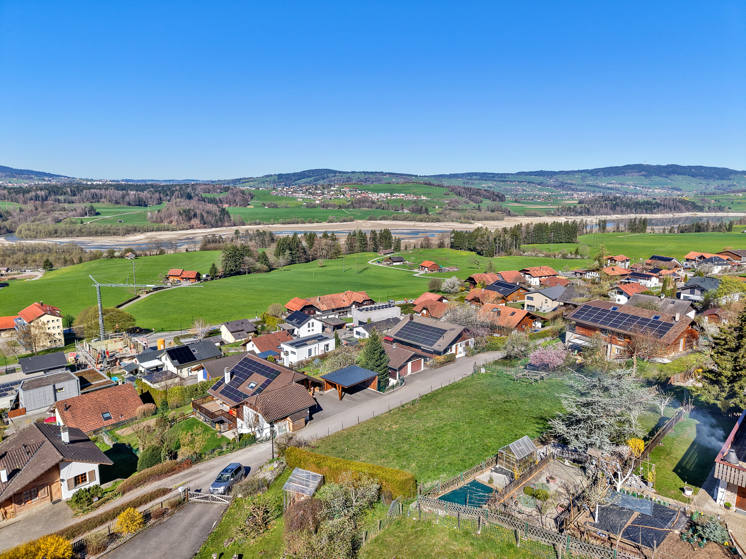 Luftaufnahme einer ländlichen Wohnsiedlung mit Flusslandschaft