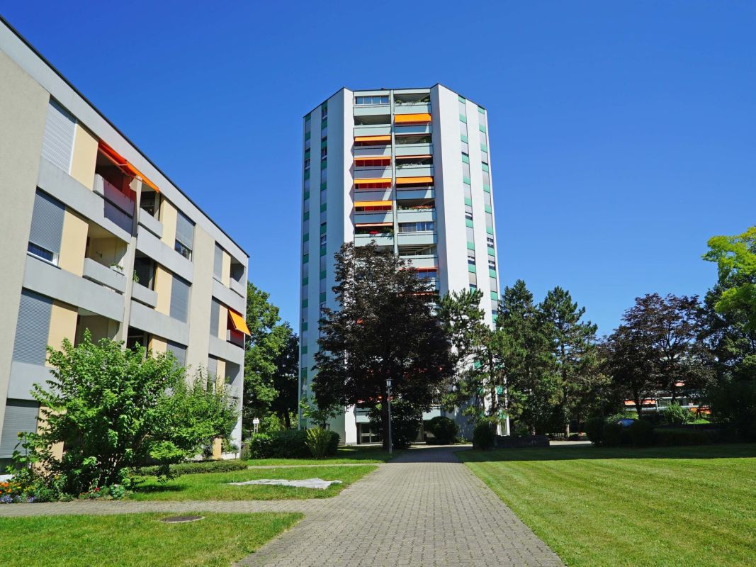 Wohnanlage mit Hochhaus und niedrigen Mehrfamilienhäusern