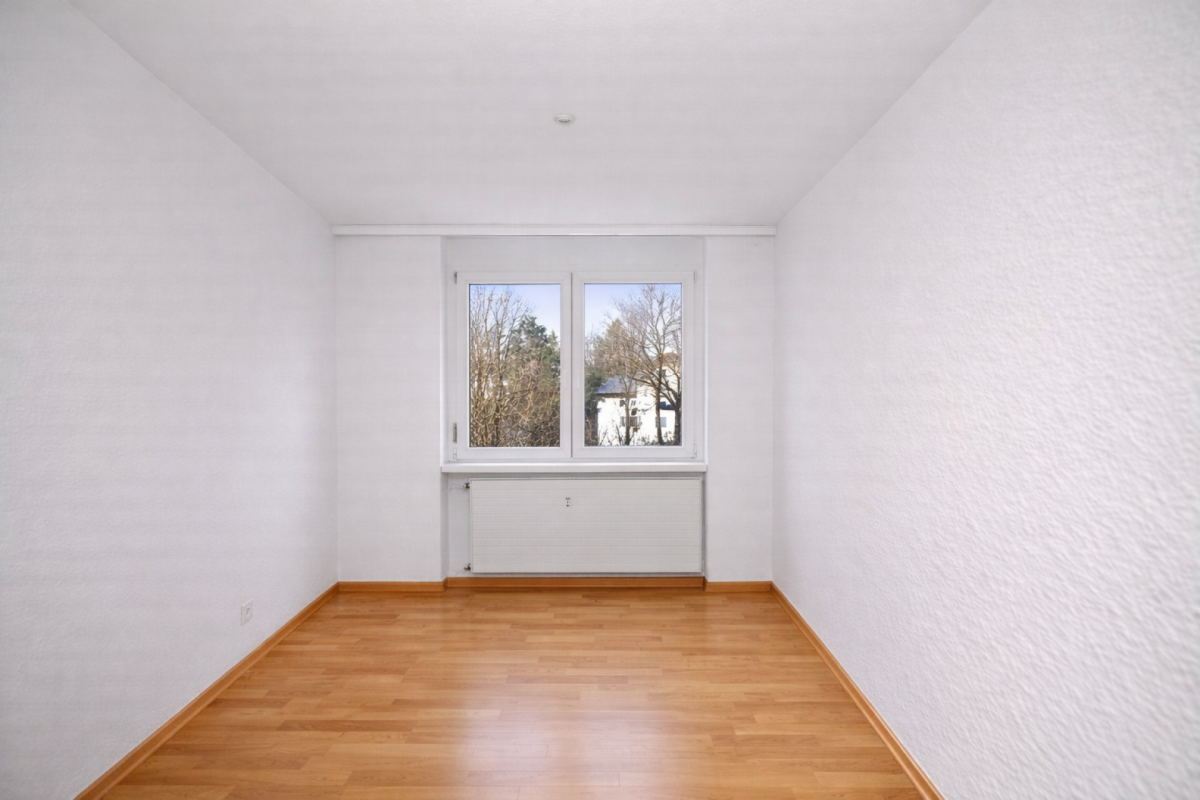 Leerer heller Raum mit Fenster und Heizkörper