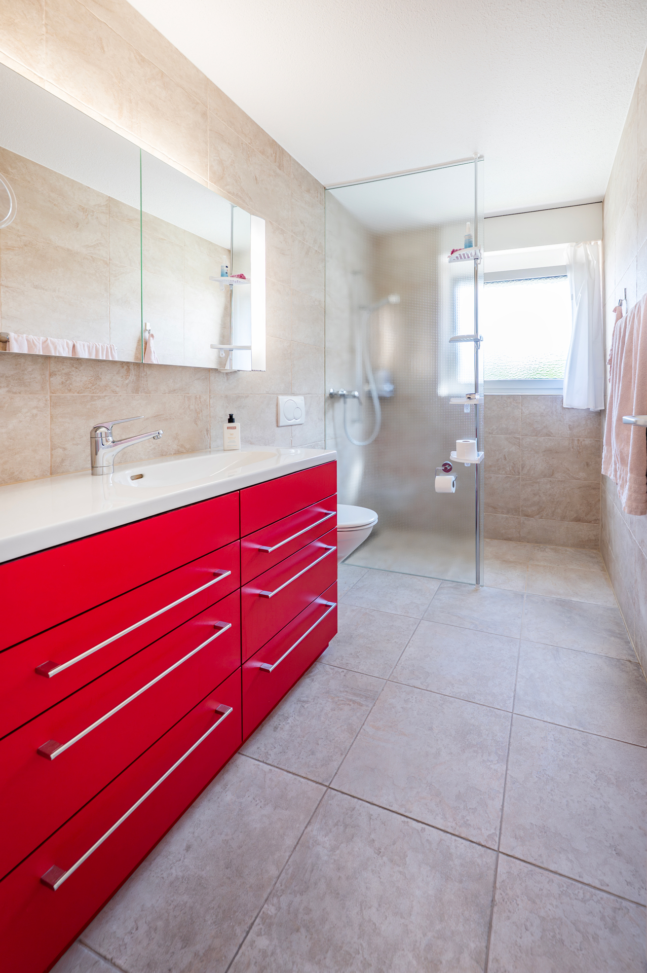 Modernes Badezimmer mit rotem Waschtischunterschrank