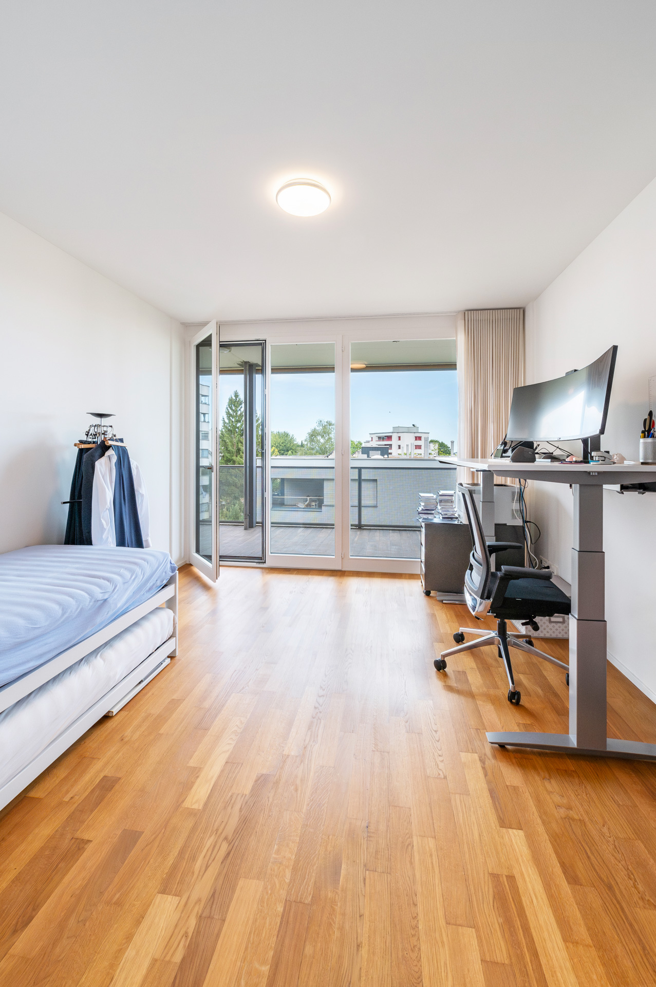 Helles Schlafzimmer mit Balkon und Arbeitsplatz