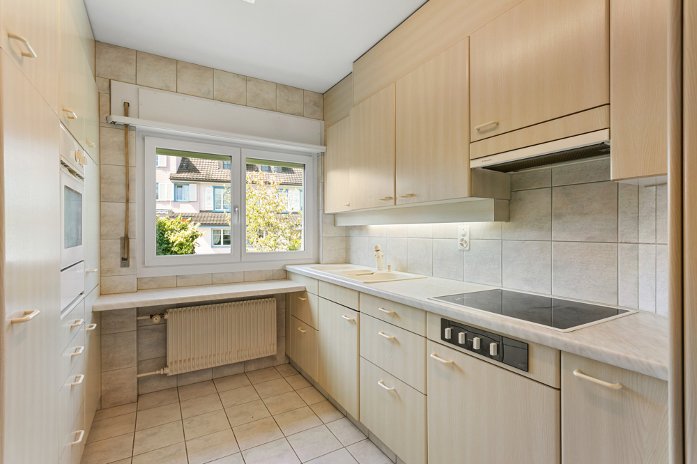 Helle Einbauküche mit Fenster und Fliesenoberflächen
