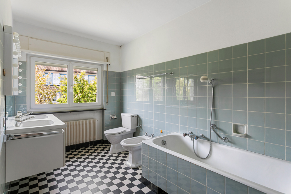 Badezimmer mit blaugrünen Fliesen und Schachbrettboden