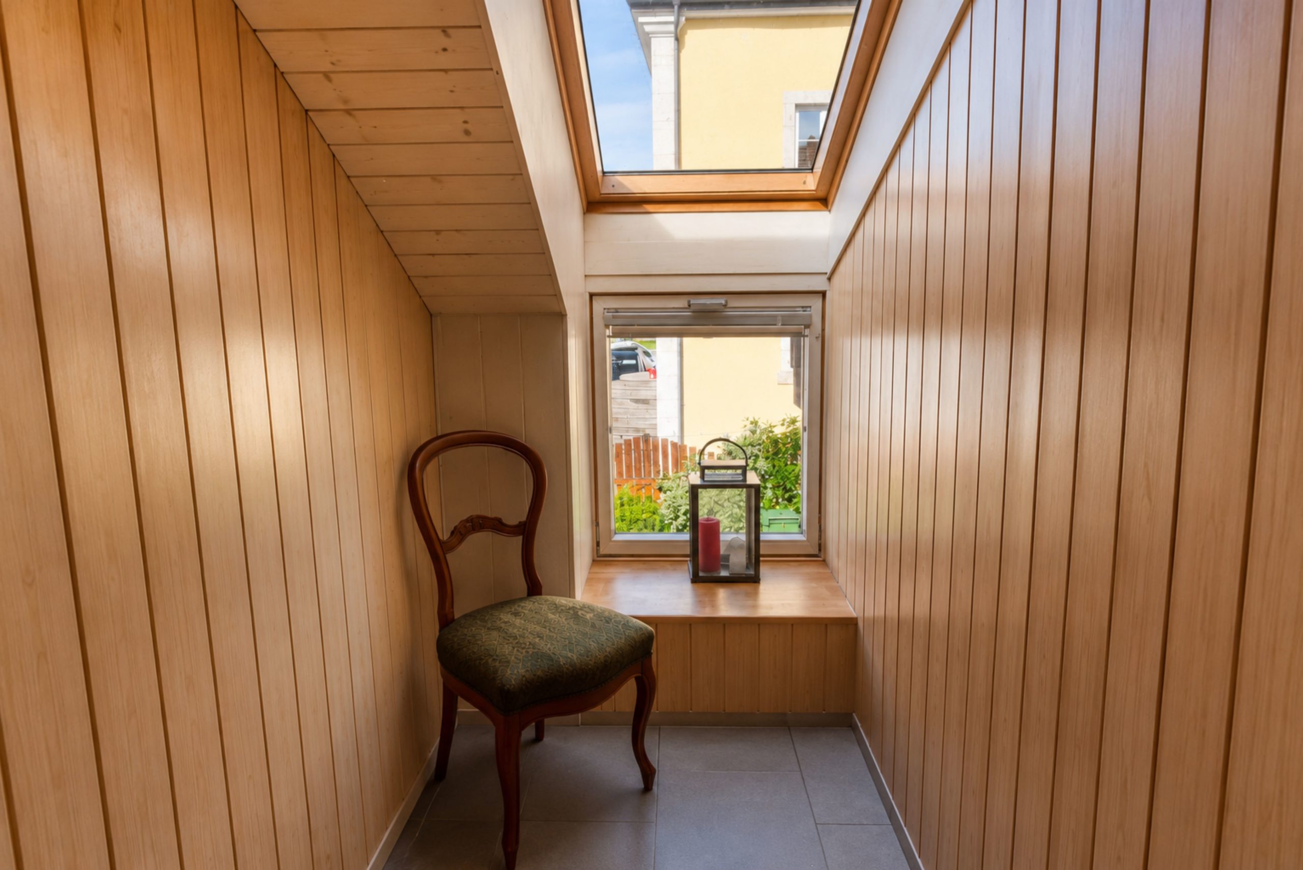 Heller Holzflur mit Dachfenster und Sitzmöbel