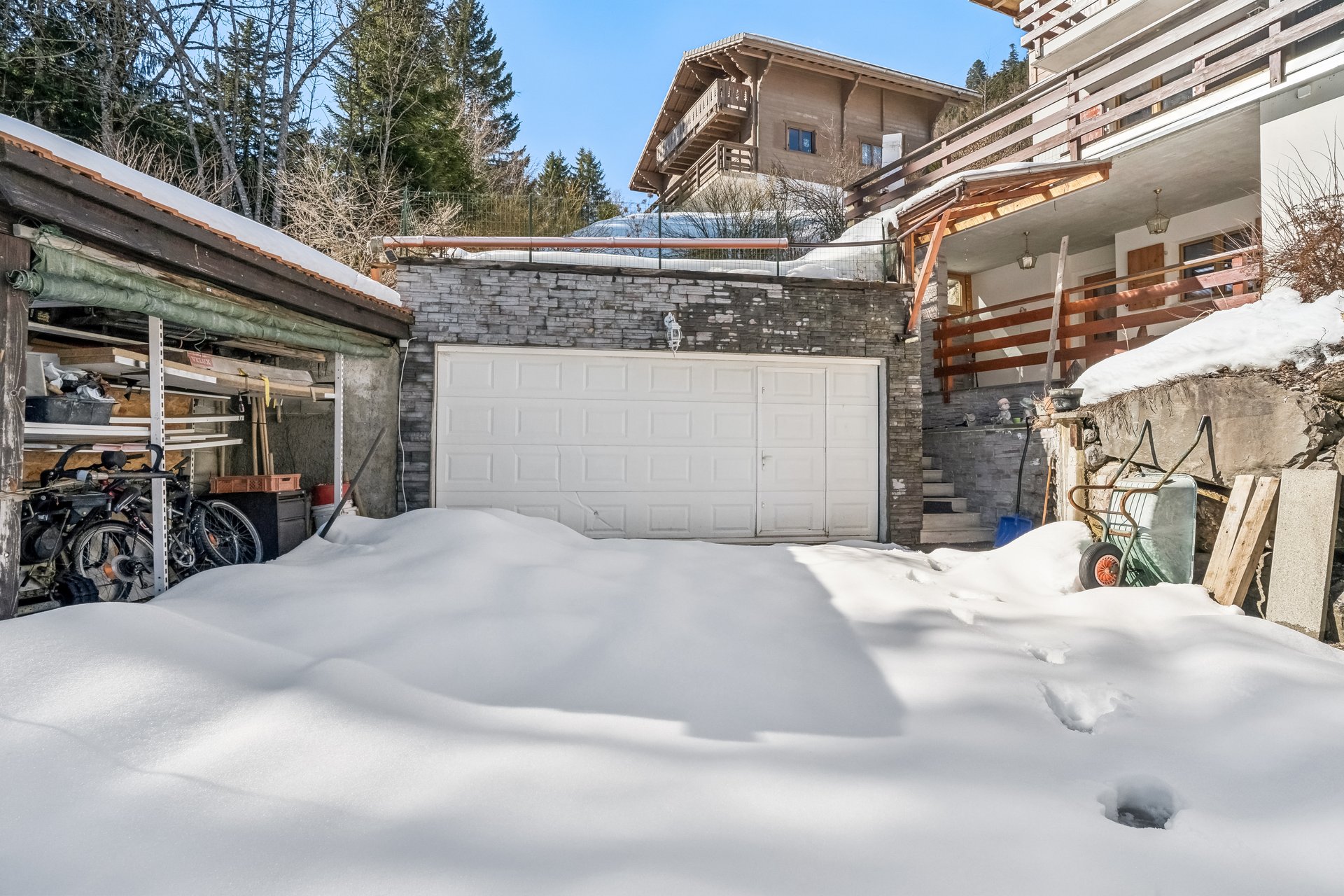 Schneebedeckter Garagenhof mit Hauszufahrt