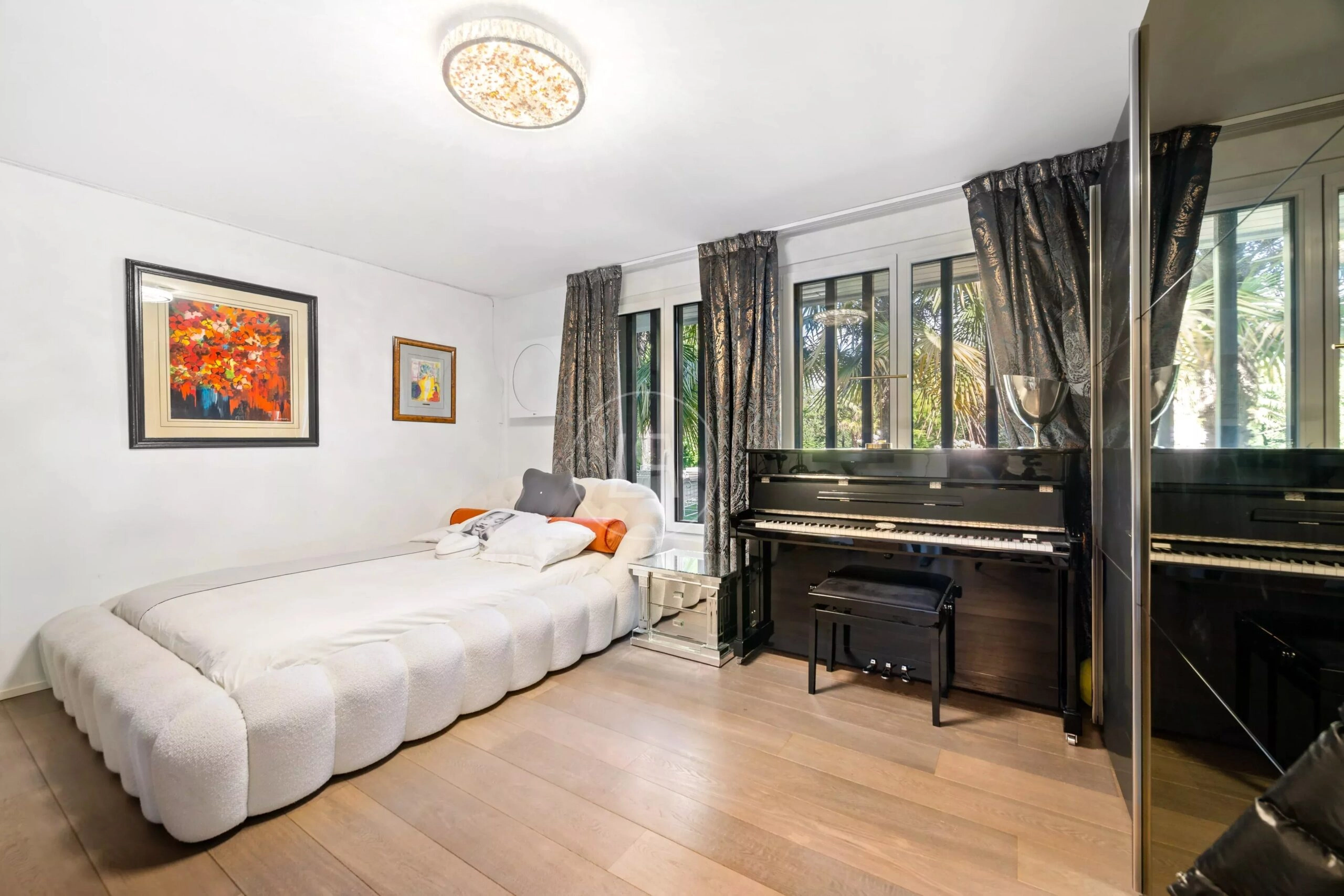 Helles Schlafzimmer mit Klavier und großen Fenstern