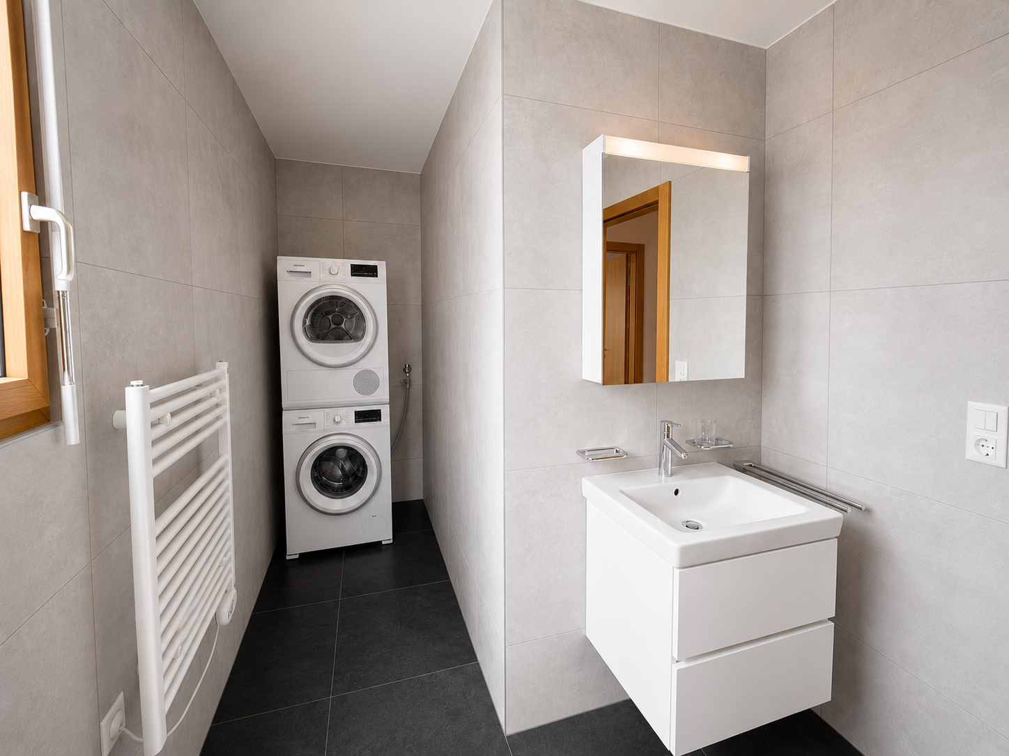 Badezimmer mit Waschmaschine und Waschtisch