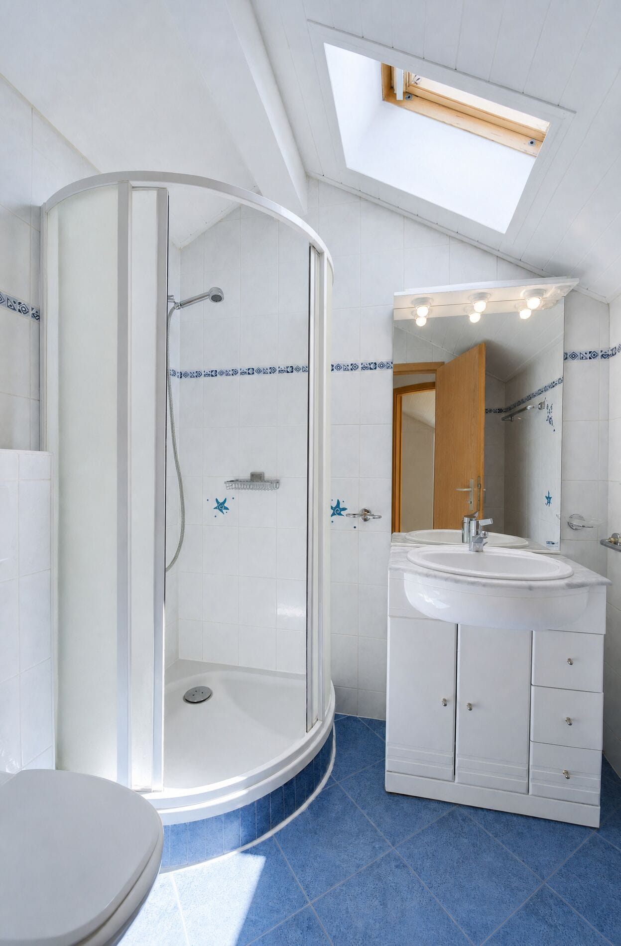 Badezimmer mit Dachfenster und Runddusche