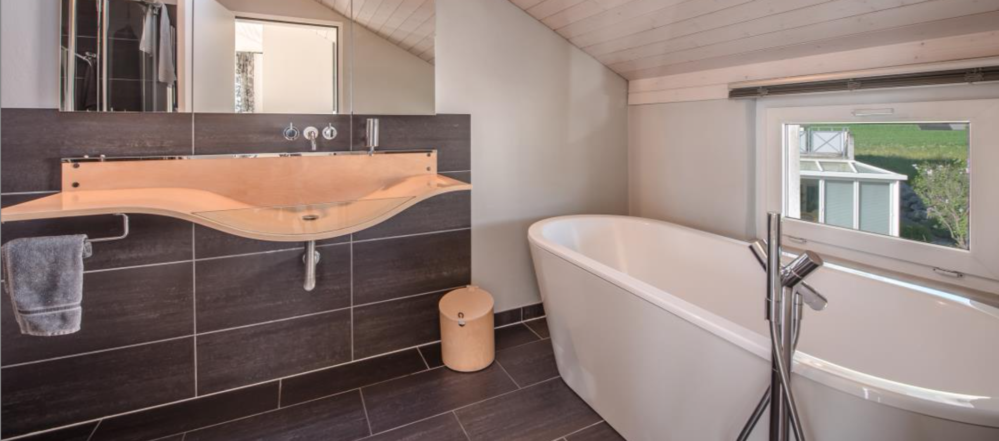 Modernes Badezimmer mit freistehender Badewanne und Fensterblick