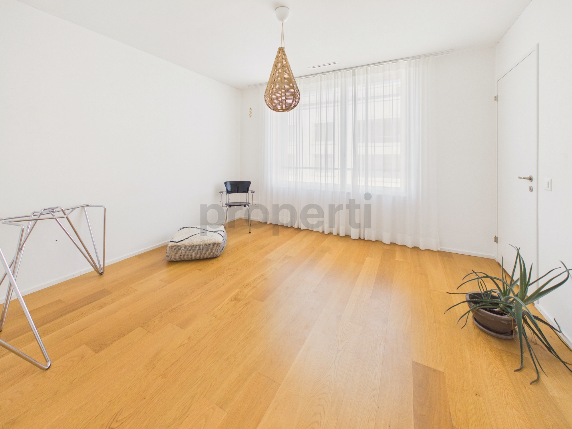 Helles, minimalistisches Zimmer mit Holzfußboden