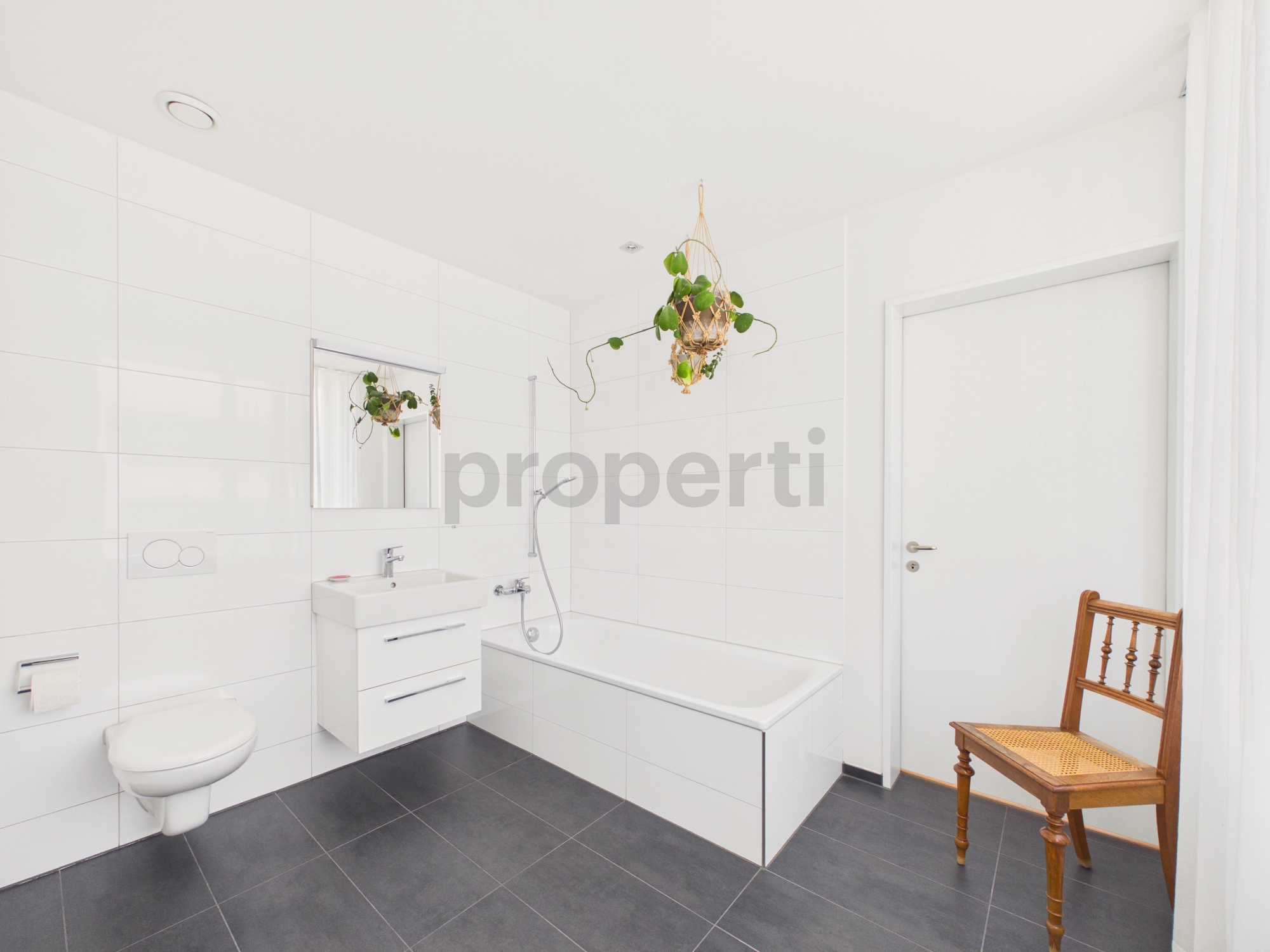 Modernes Badezimmer mit weißer Wandverfliesung und dunklem Boden