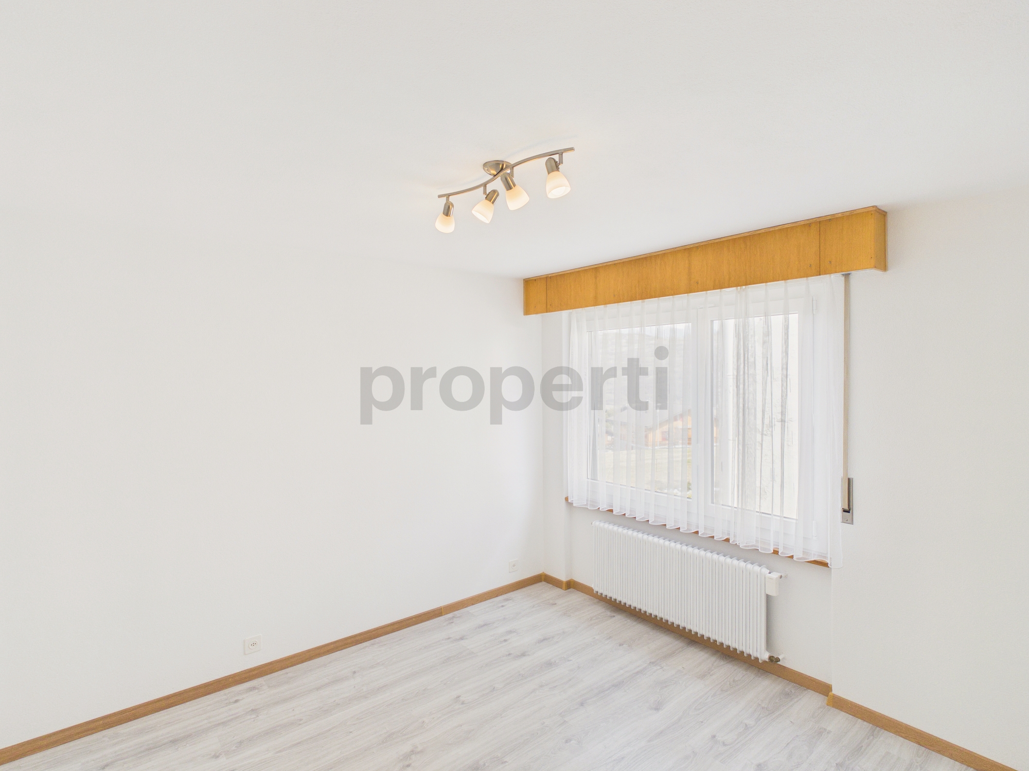 Heller leerer Wohnraum mit Fenster und Heizkörper