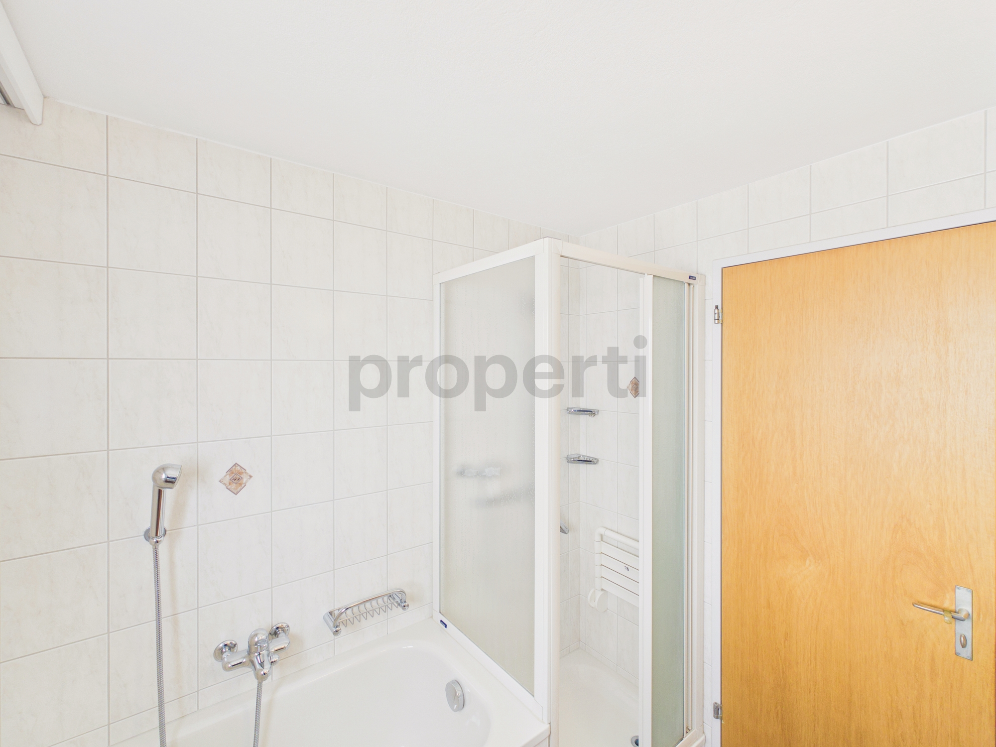 Badezimmer mit Badewanne und Duschabtrennung