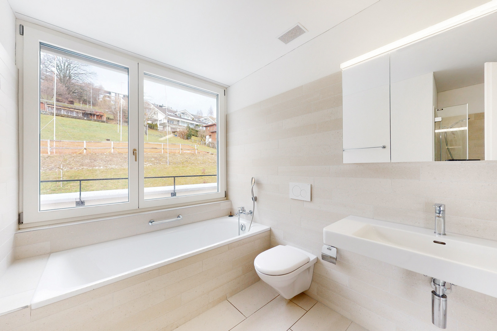Helles Badezimmer mit Badewanne, WC und Waschtisch