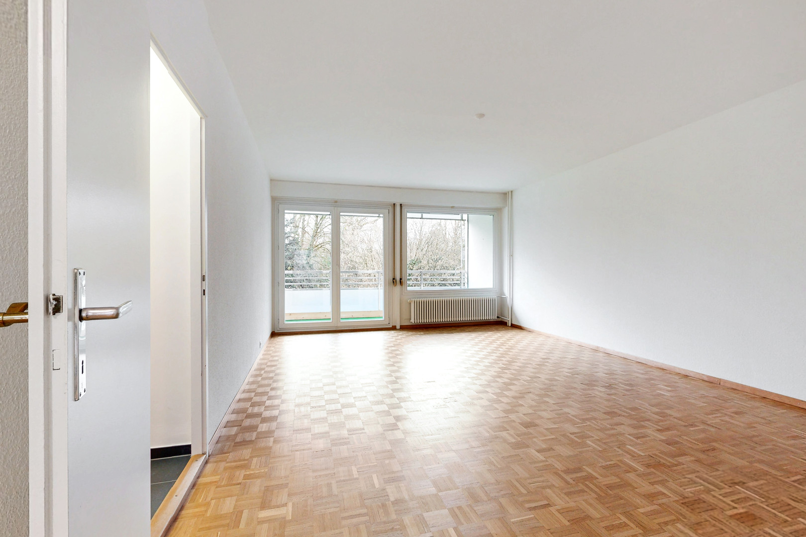 Leeres Wohnzimmer mit Balkonzugang