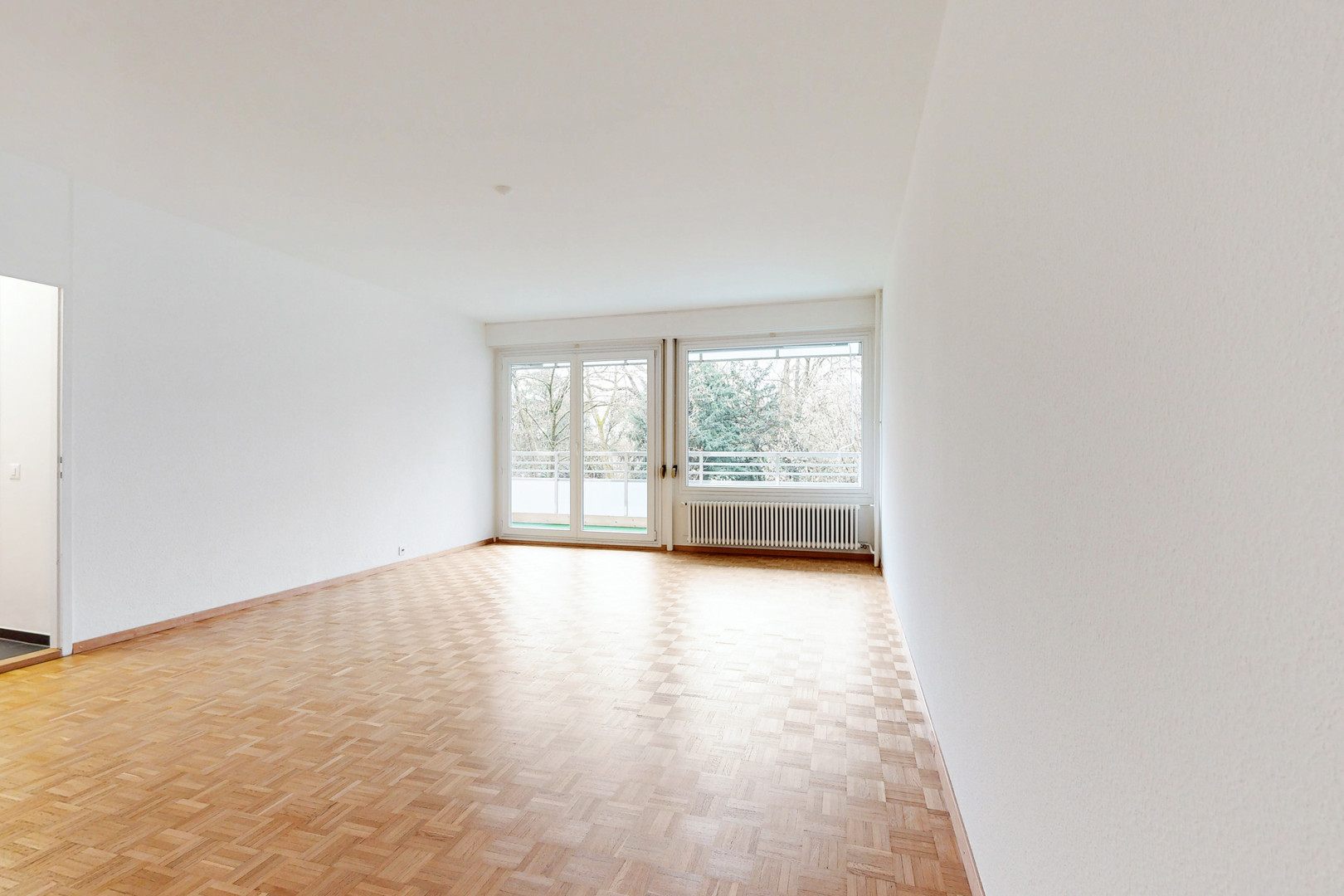 Heller leerer Wohnraum mit Balkonzugang