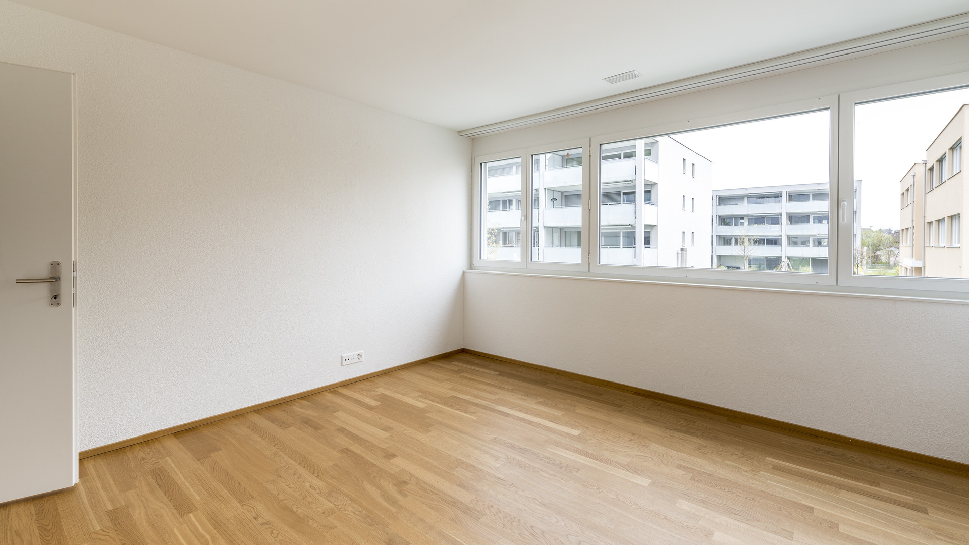 Helles, leeres Zimmer mit großem Fensterband