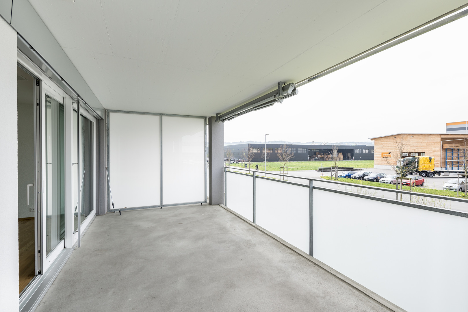 Überdachter Balkon mit Blick auf ein Gewerbeareal