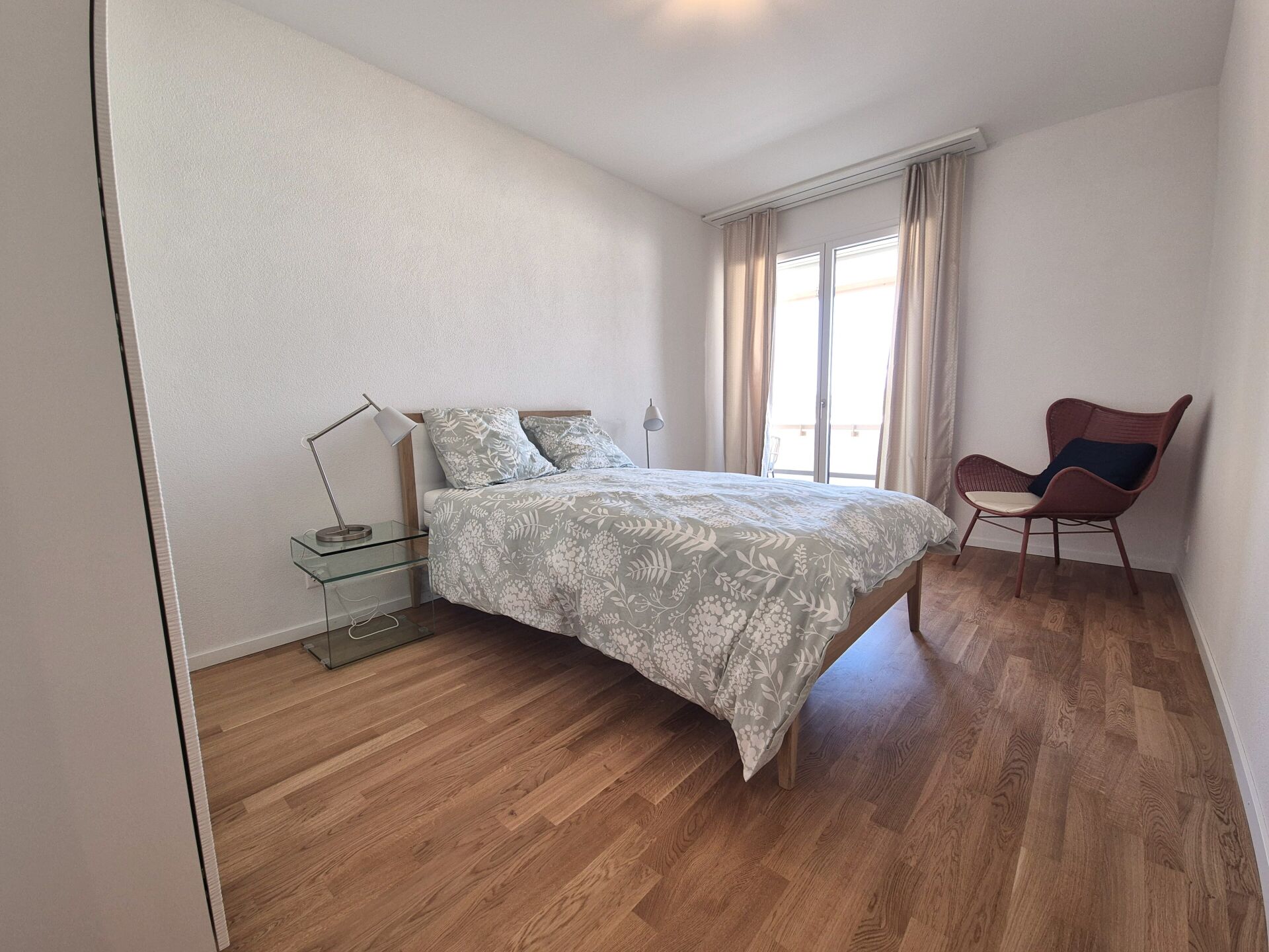 Helles Schlafzimmer mit Doppelbett und Balkonfenster