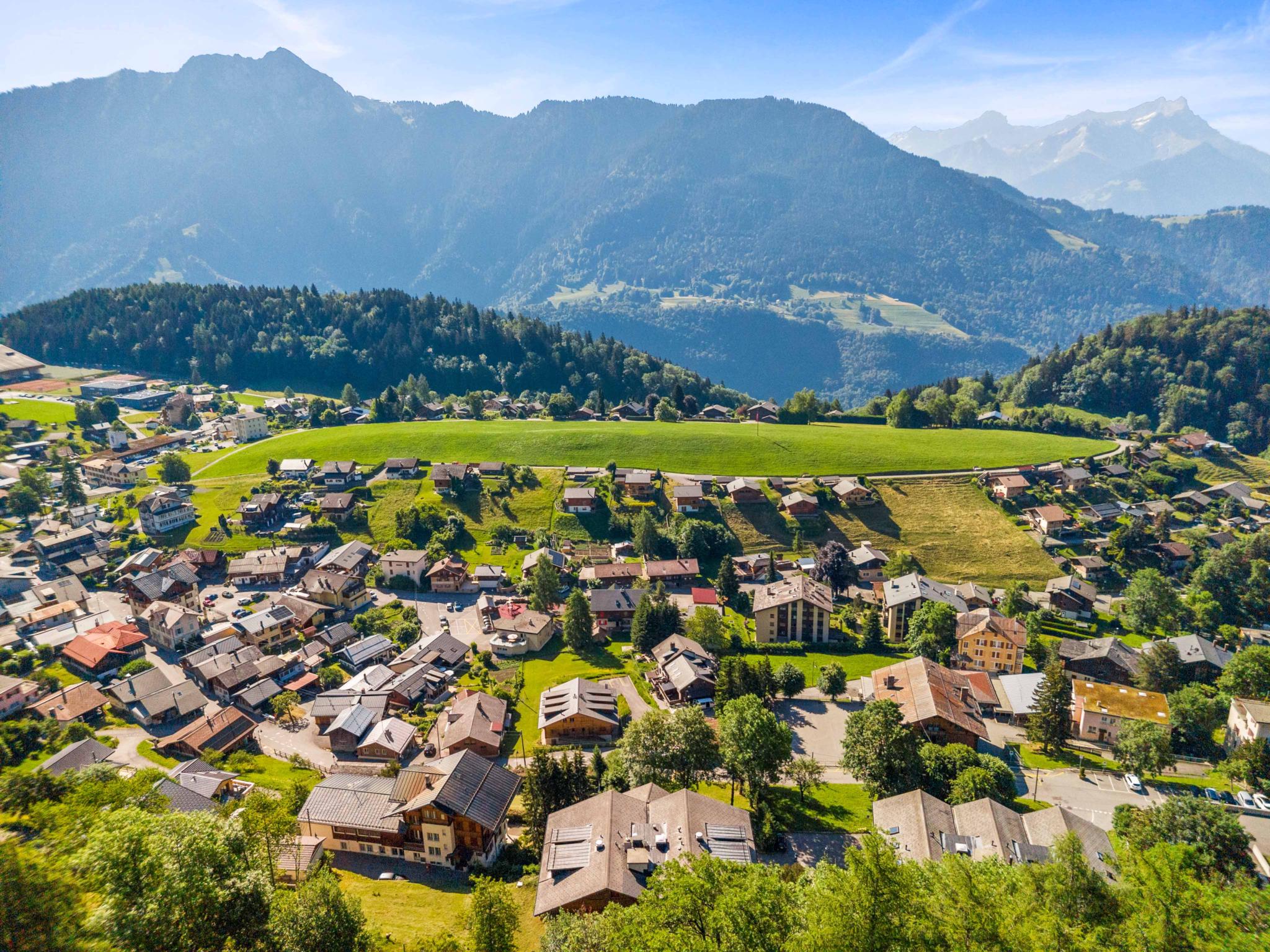 Luftaufnahme eines alpinen Dorfes mit Bergpanorama
