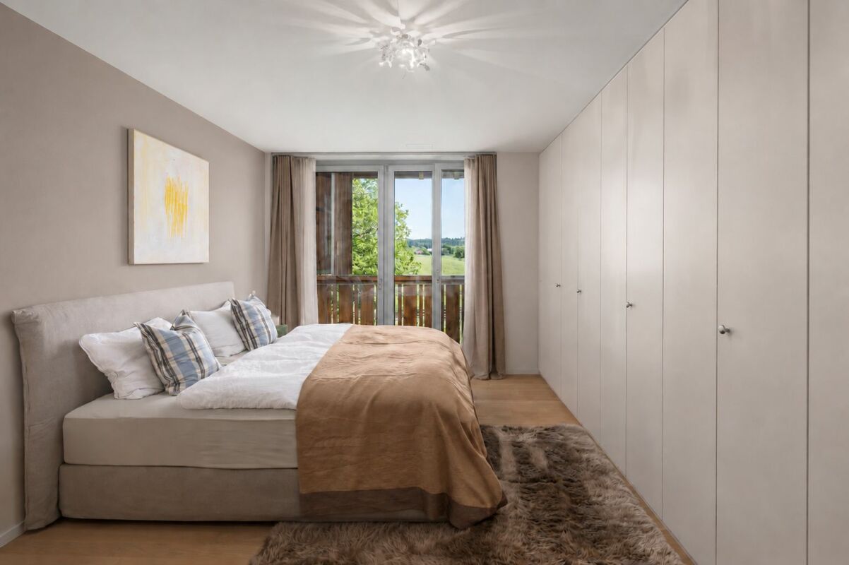 Helles Schlafzimmer mit Einbauschränken und Balkonblick