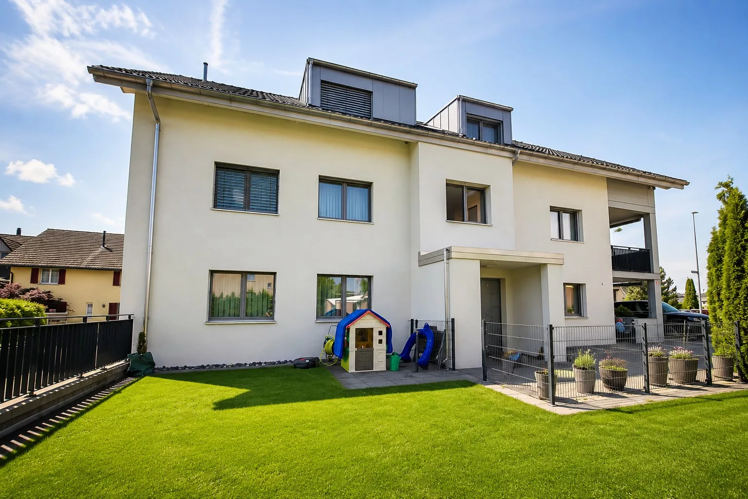 Außenansicht eines modernen Mehrfamilienhauses mit Garten