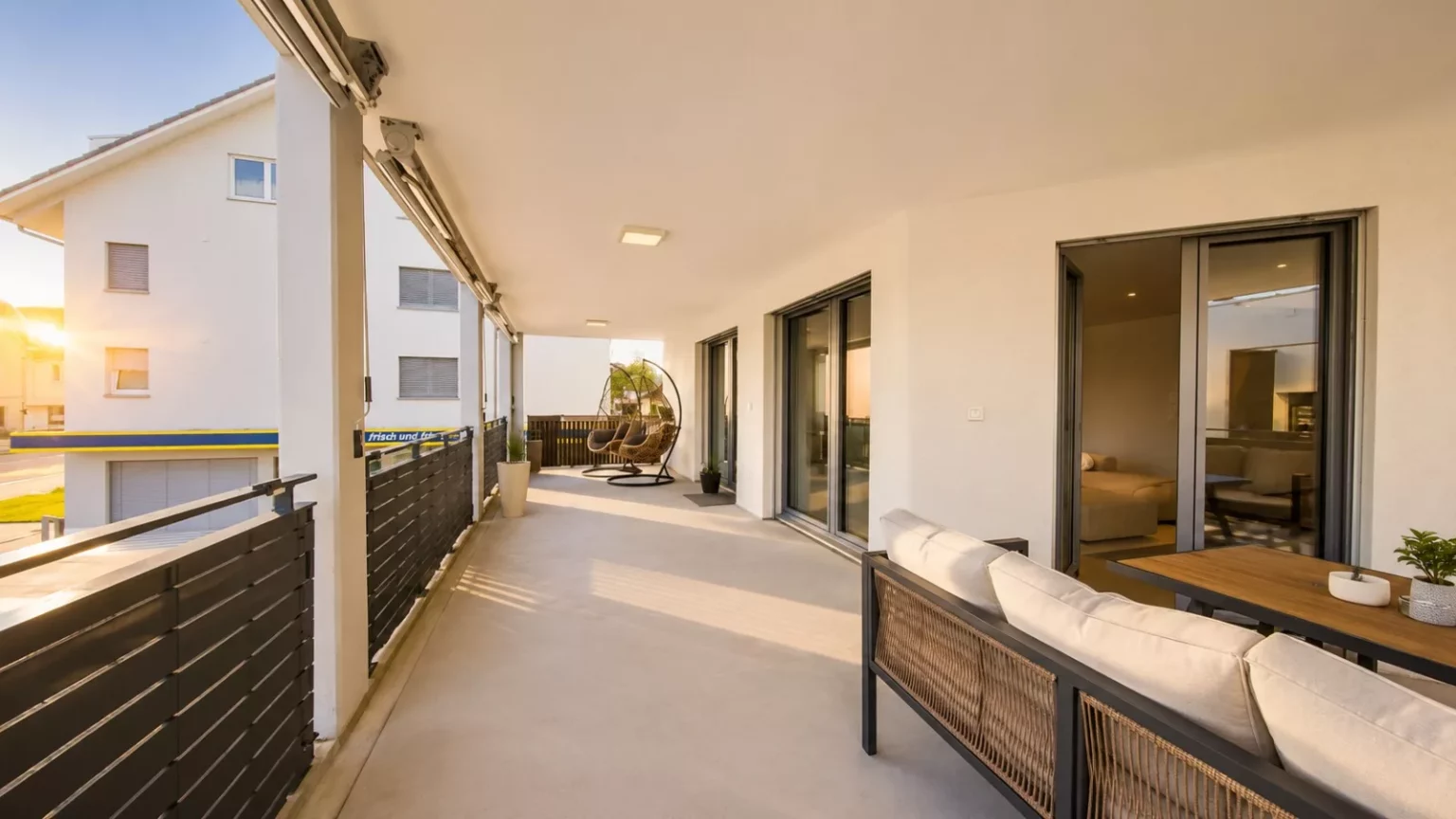 Überdachter Balkon mit Sitzbereich bei Sonnenuntergang
