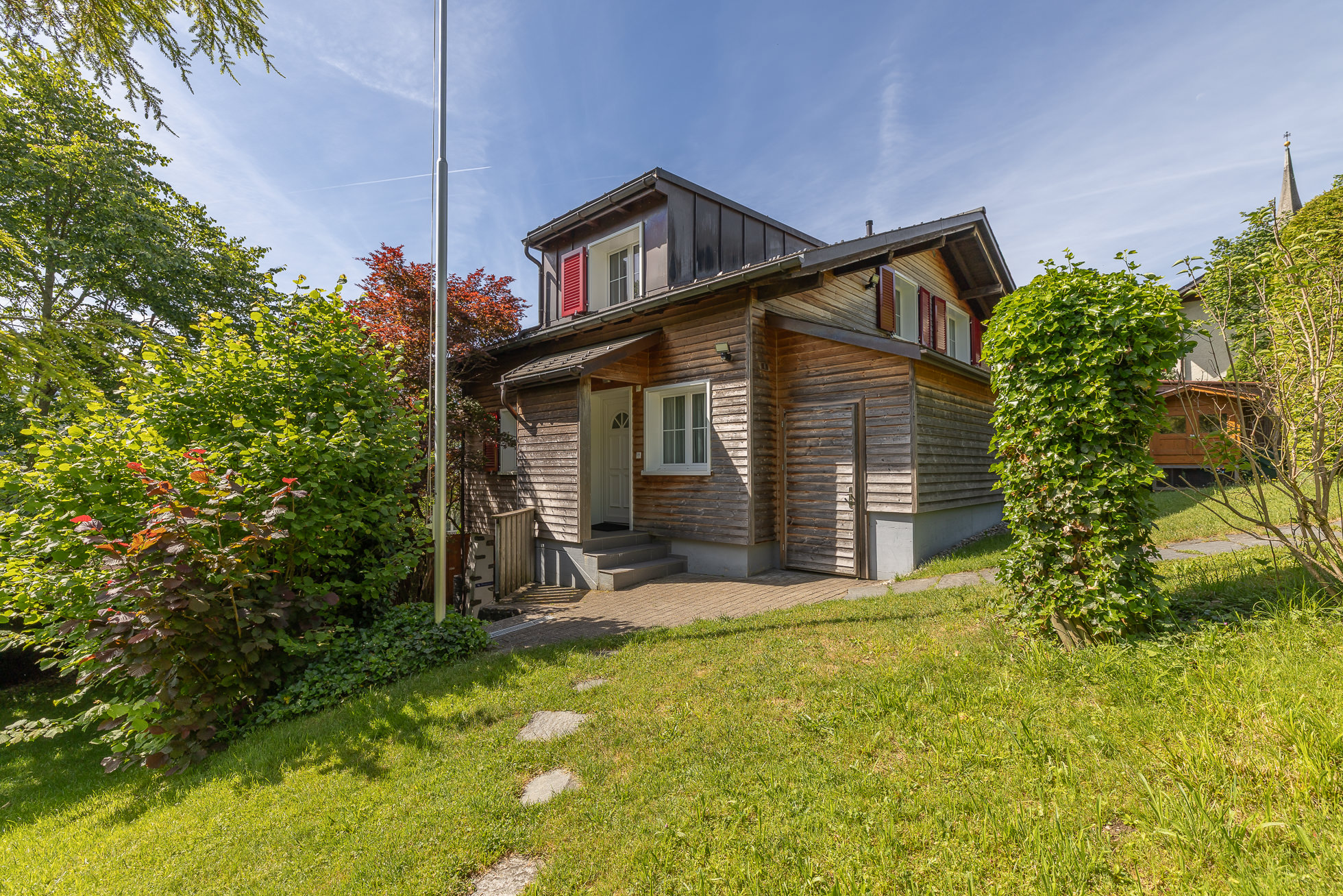 Außenansicht eines Holzhauses mit Garten