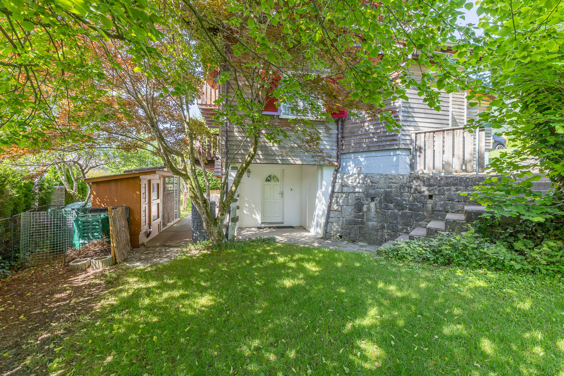 Gartenansicht eines Hauses mit Zugang und Nebengebäude