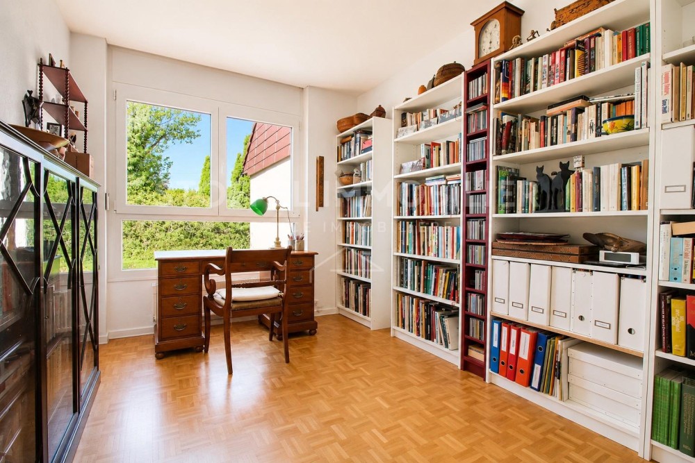 Helles Arbeitszimmer mit Bücherregalen und Schreibtisch