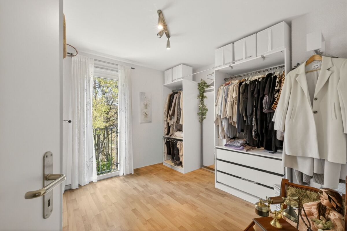 Helles Ankleidezimmer mit Fenster zum Balkon