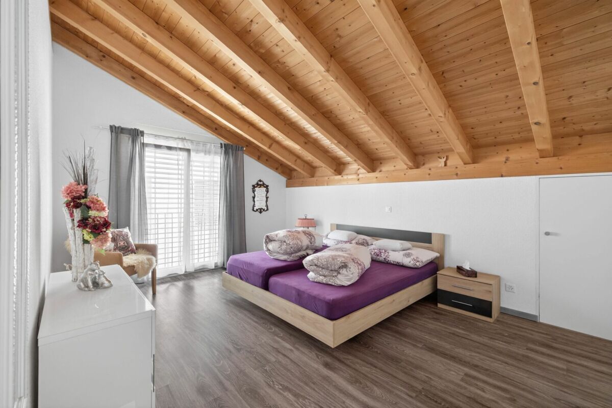 Helles Schlafzimmer mit Holzbalkendecke
