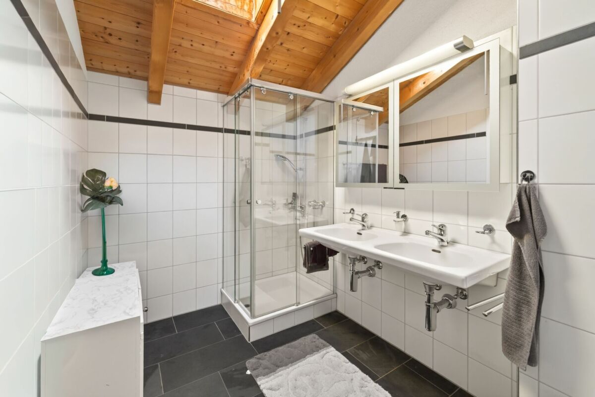 Modernes Badezimmer mit Holzbalkendecke