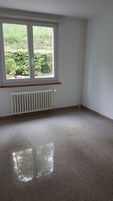 Leerer heller Raum mit Fenster und Heizkörper