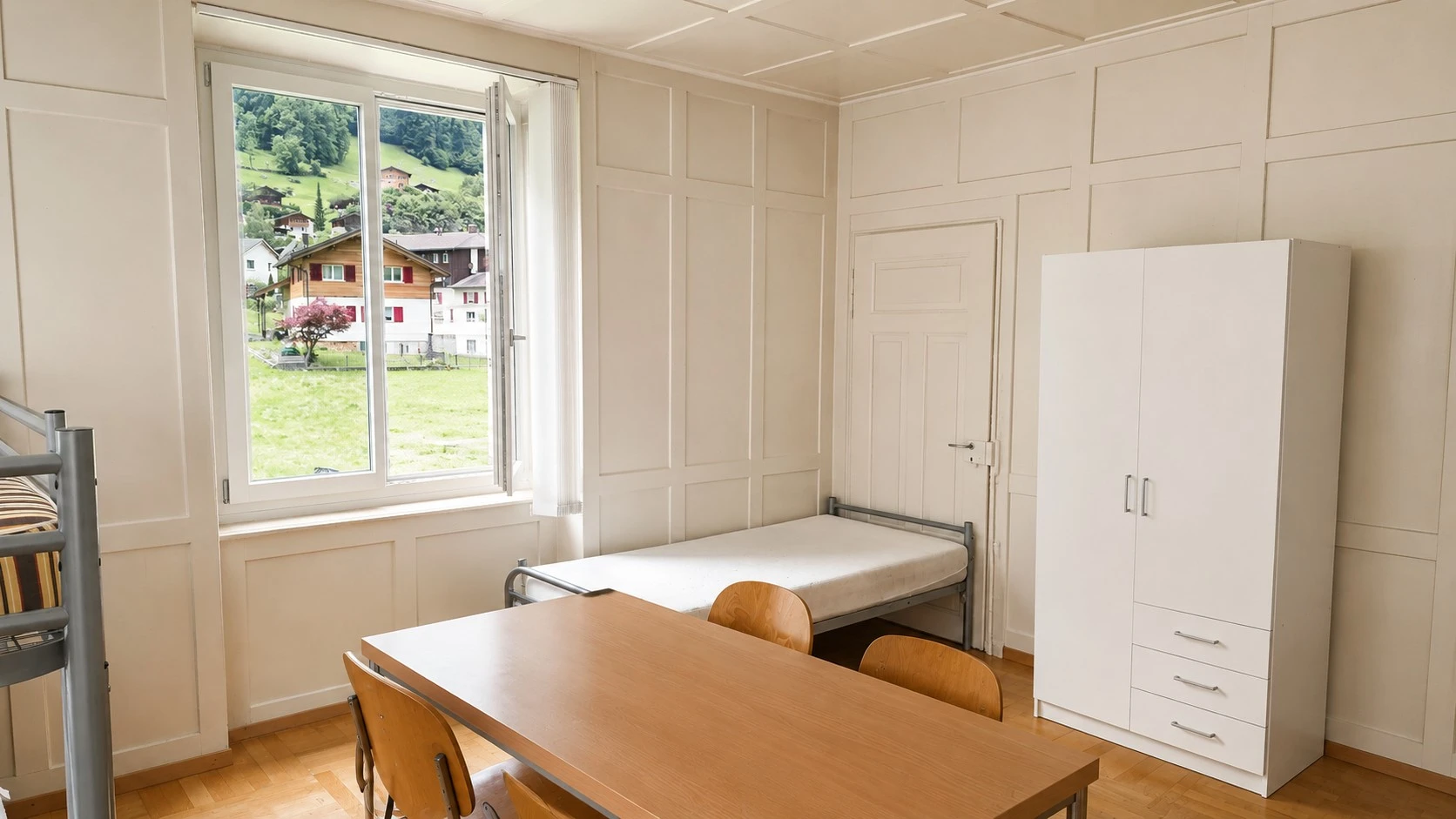 Schlichtes Schlafzimmer mit Blick ins Grüne