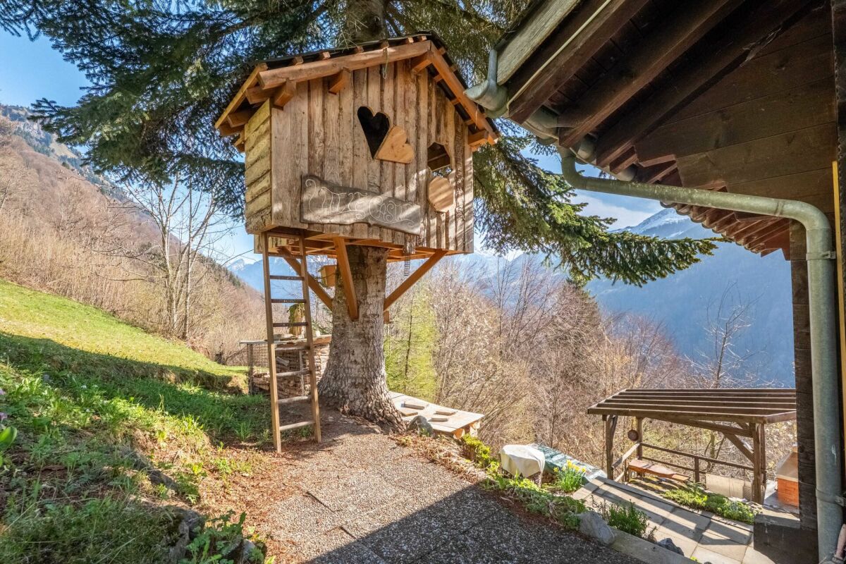 Alpiner Außenbereich mit Baumhaus