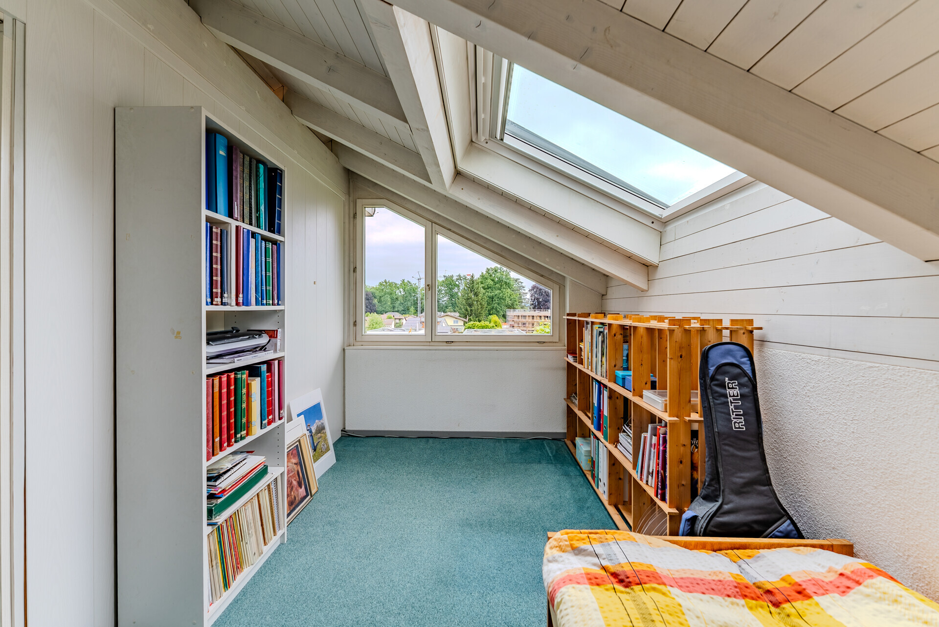 Dachzimmer mit Dachfenster und Regalen