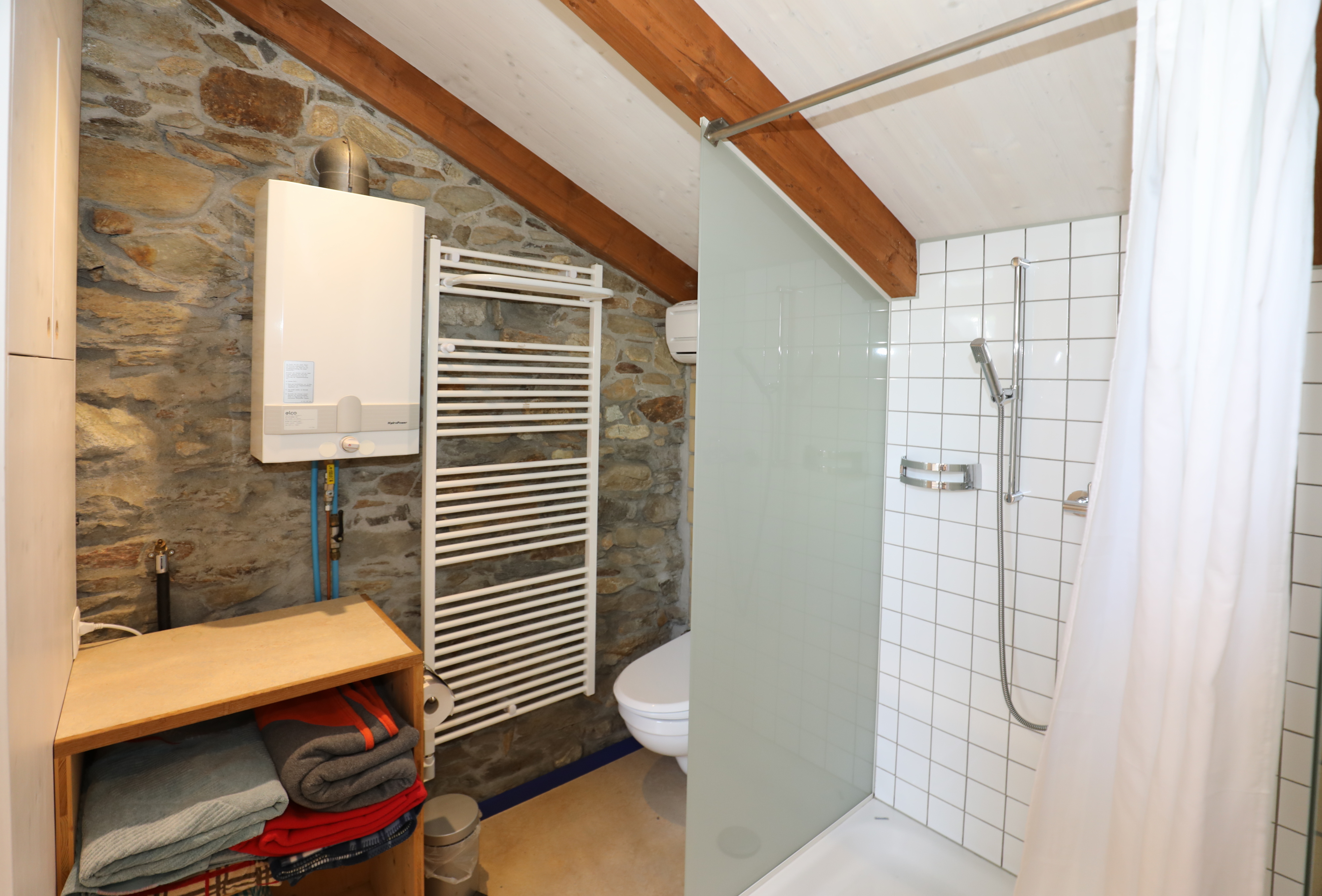 Kleines Badezimmer mit Dusche und Natursteinwand