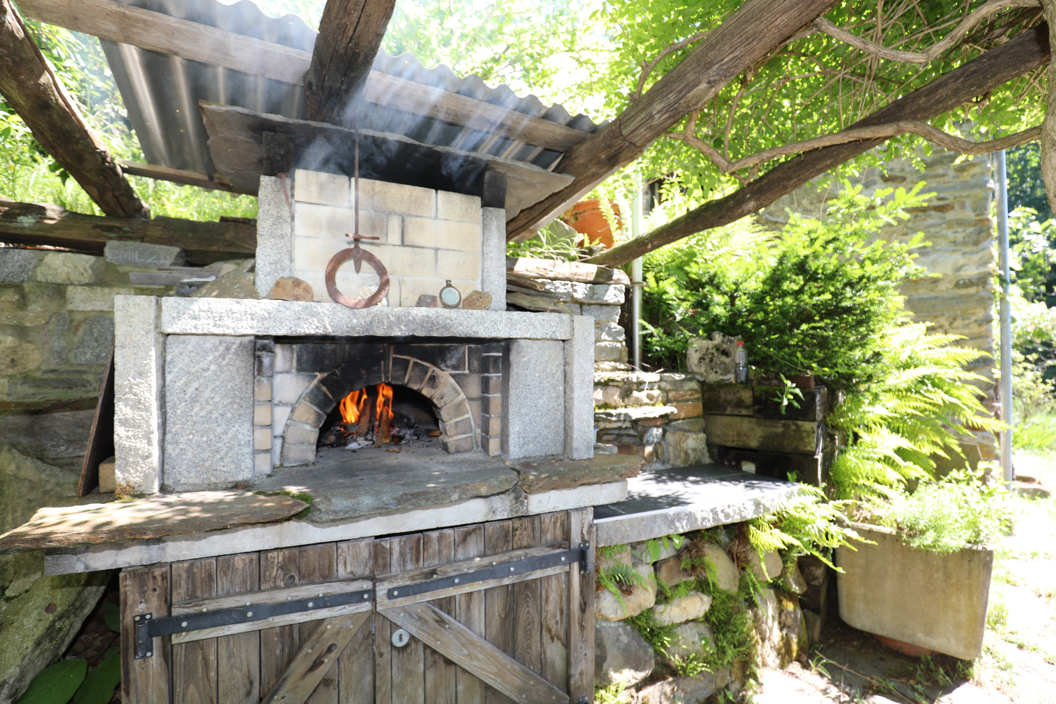 Außenbereich mit Holzofen und gemauertem Backofen